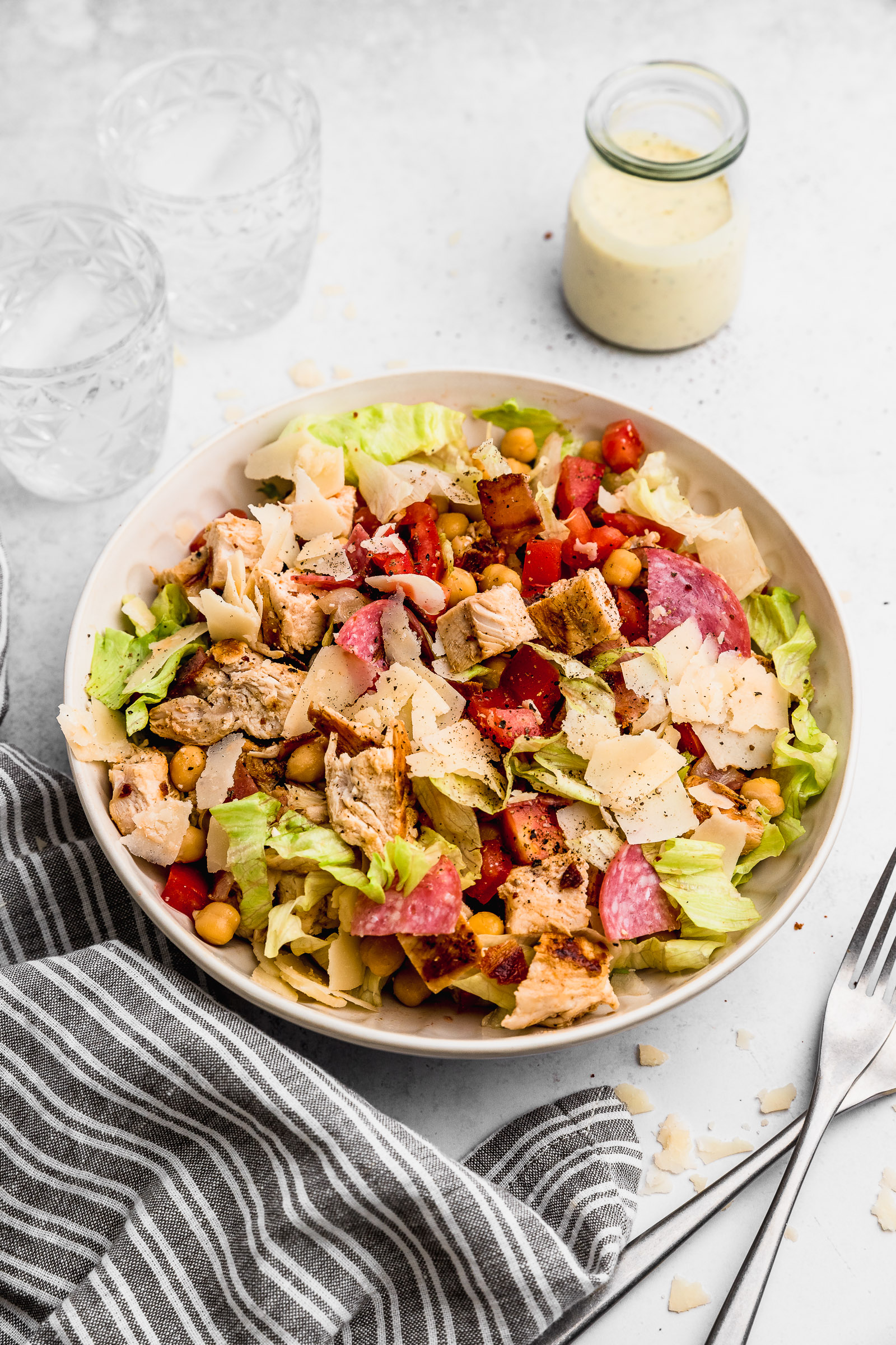 Jennifer Aniston's Salad that she ate on the set of FRIENDS. A Cobb salad with lettuce, chickpeas, tomatoes, salami, chicken, bacon, and pecorino cheese. Italian dressing in a jar on the side.