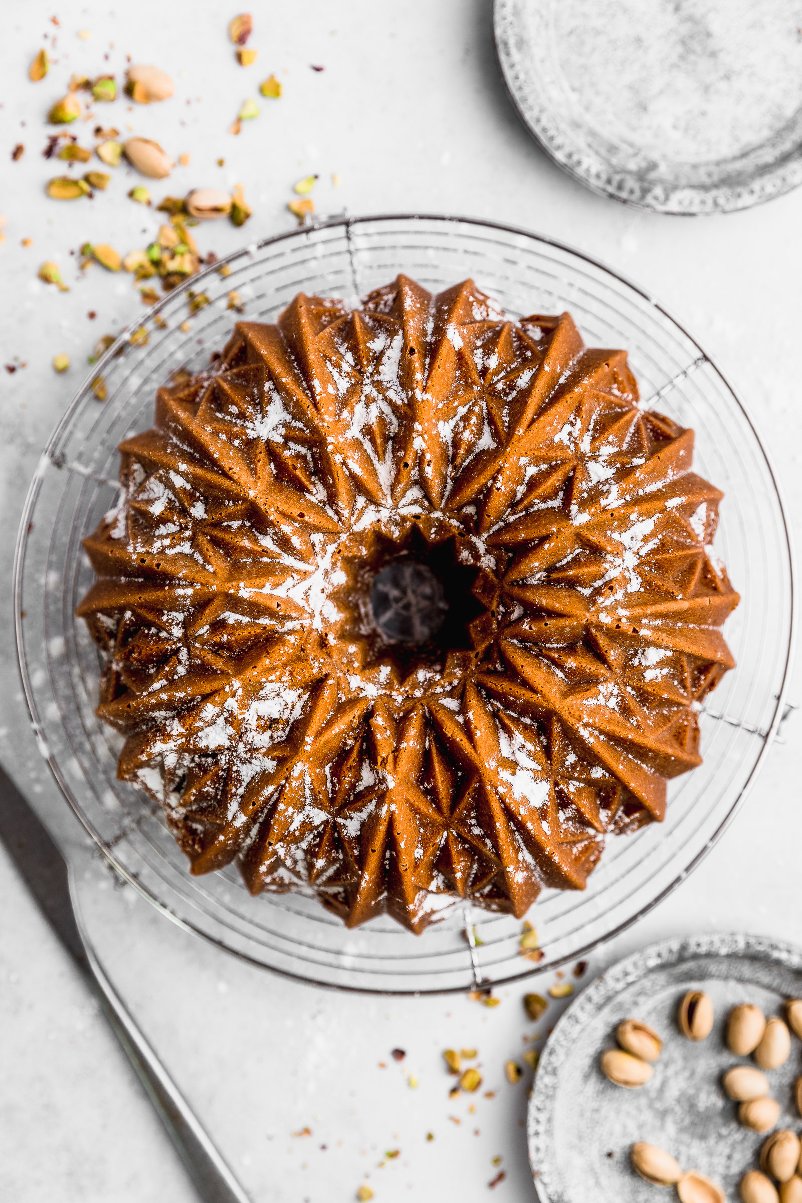 top view of a pistachio bundt cake, dusted with icing sugar.