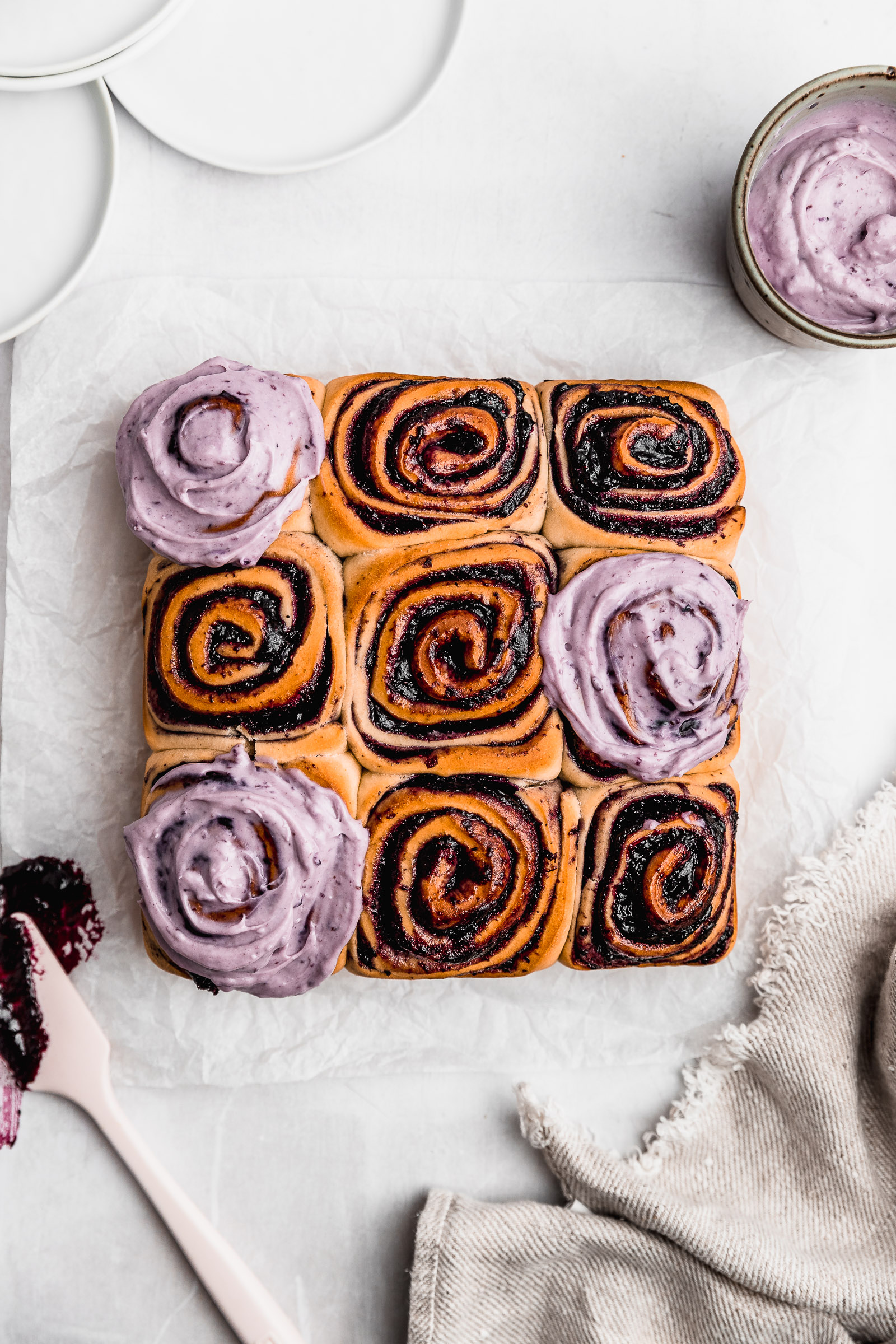 Top view of Blueberry Cinnamon Rolls (Blueberry Rolls), with some of them topped with blueberry cream cheese frosting.