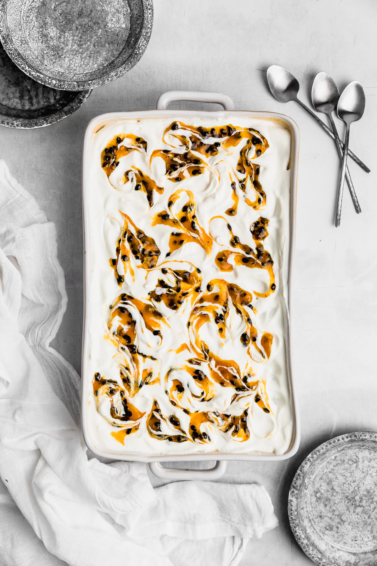 Top view of a passion fruit tres leches, showing the whipped cream marbled with passion fruit sauce.